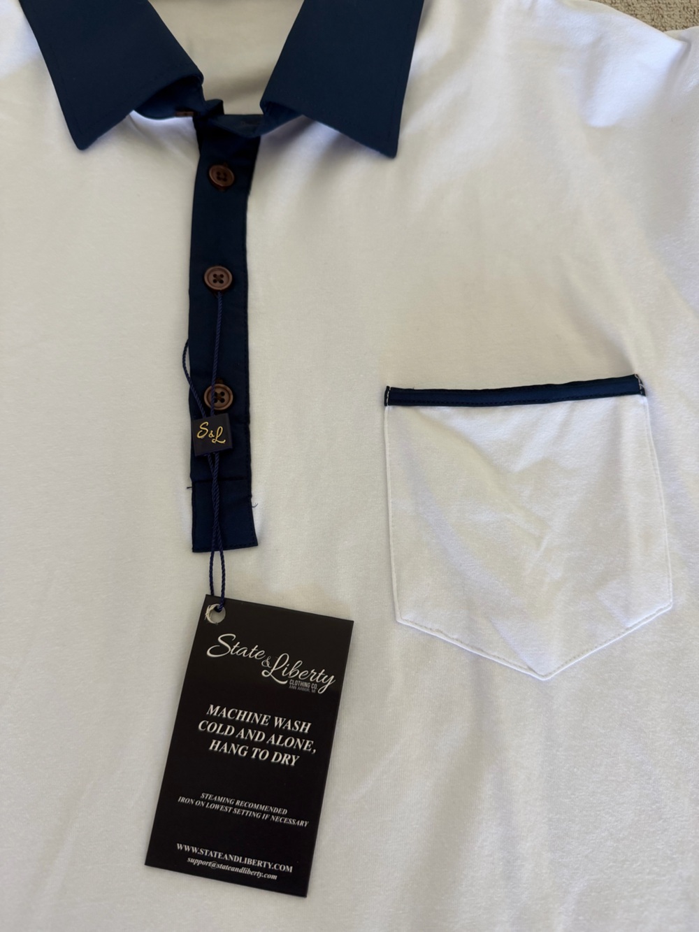 Brand new State & Liberty men’s polo in crisp white with navy contrast details 💥